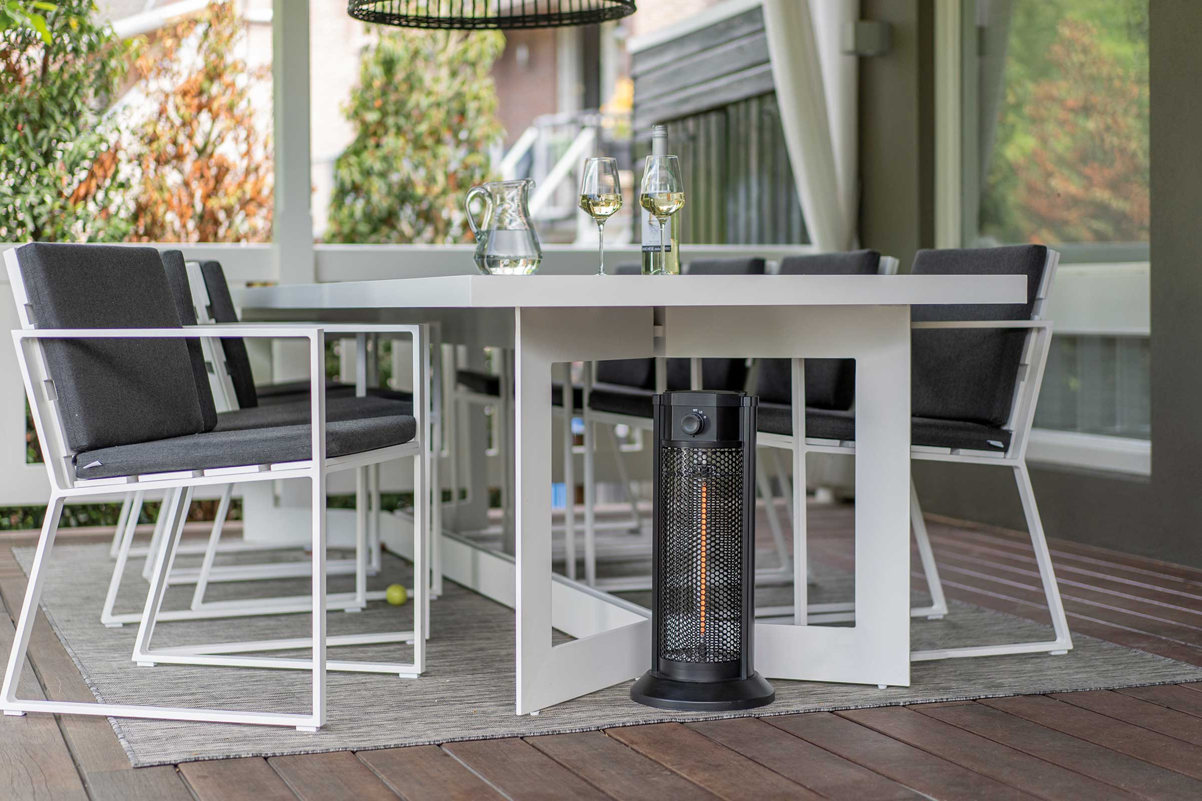 Scène de terrasse avec table de jardin blanche, chaises et chauffage de terrasse noir pour une ambiance extérieure conviviale