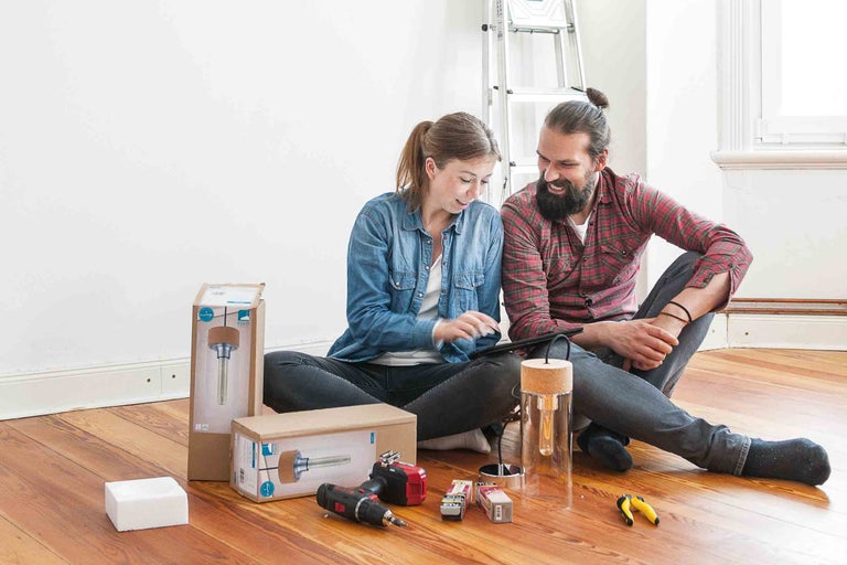 Paar plant eine Wohnraumrenovierung mit Werkzeugen und einer Lampe