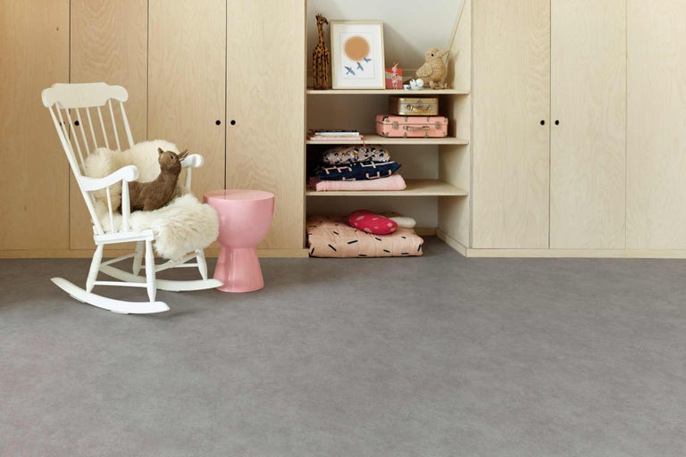 Chambre d'enfant avec armoire en bois, étagères, rocking-chair blanc et sol gris