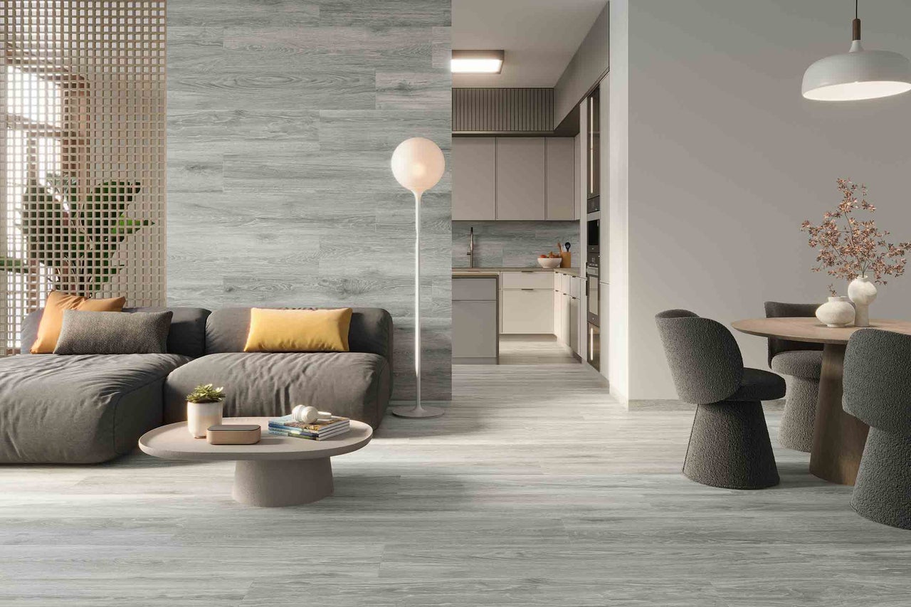 Salon lumineux avec carrelage de sol imitation bois, canapé et coin repas