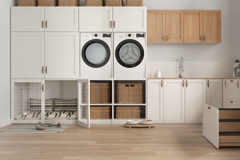 Buanderie avec lave-linge, sèche-linge, armoires, paniers et espace pour chien