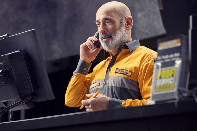 Ein Hornbach Mitarbeiter telefoniert am Serviceschalter.