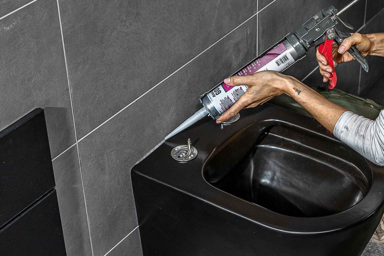 Anwendung von Dichtstoff mit einer Kartuschenpistole an einem Bidet