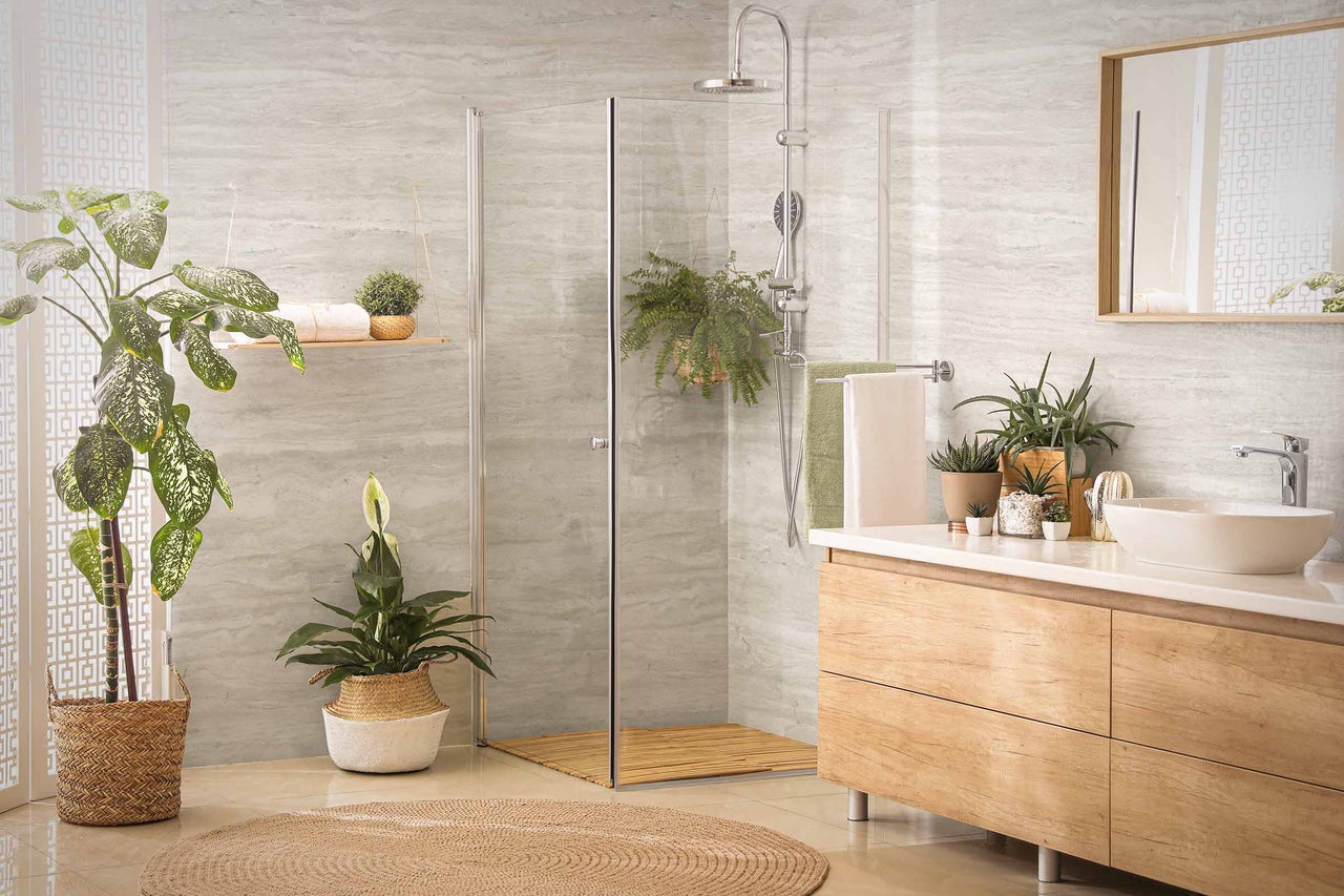 Helles Badezimmer mit Dusche, Waschtisch und Pflanzen