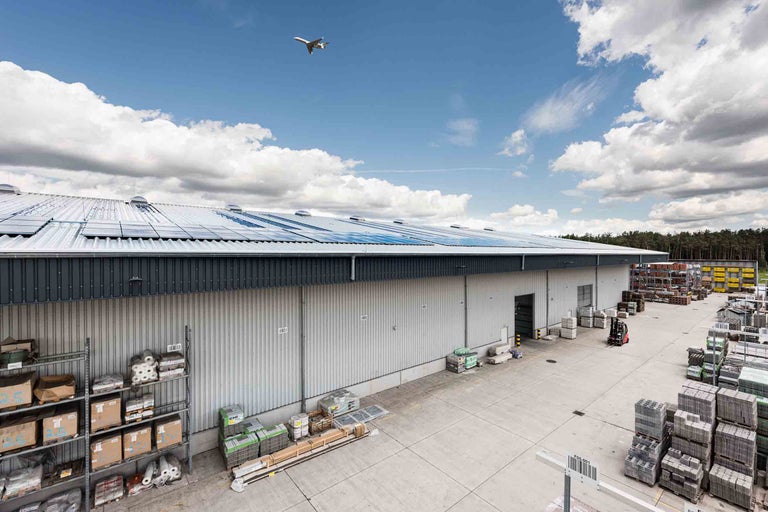 Außenansicht eines Hornbach Baumarktes mit Solaranlagen auf dem Dach und Lagerflächen