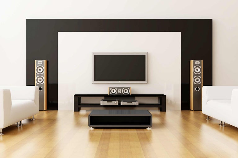Wohnzimmer mit Fernseher, Lautsprechern, Lowboard und Couch