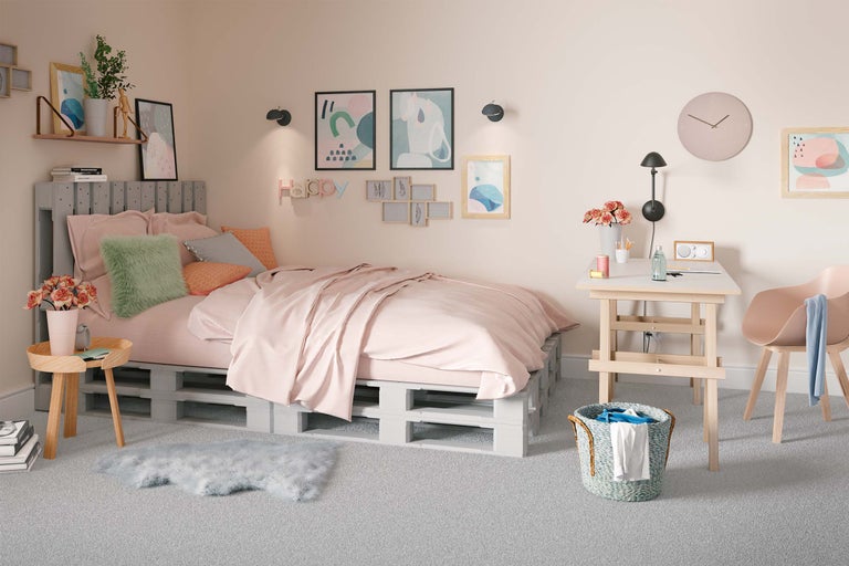 Helles Schlafzimmer mit Palettenbett, Schreibtisch und Dekoration