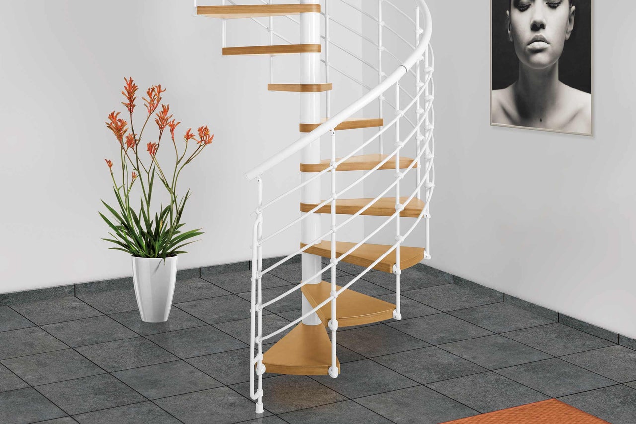 Scène d'intérieur avec escalier en colimaçon avec marches en bois et rambarde blanche.