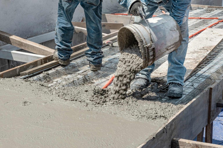 Bauarbeiter gießen Beton auf einer Baustelle