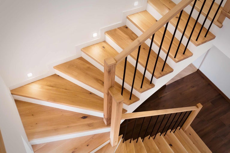 Escalier en bois avec rampe noire dans un intérieur clair