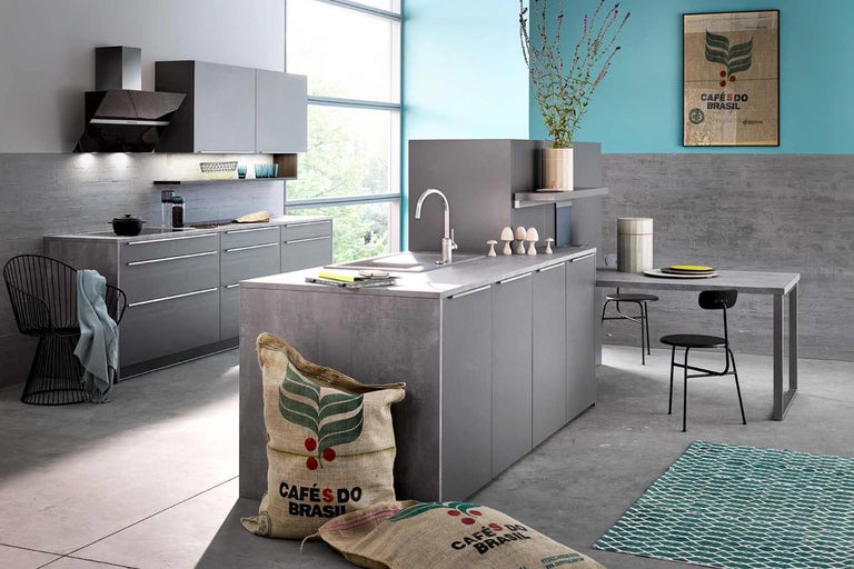 Moderne Küche mit Kochinsel, Esstisch und Stühlen in einem hellen Raum.