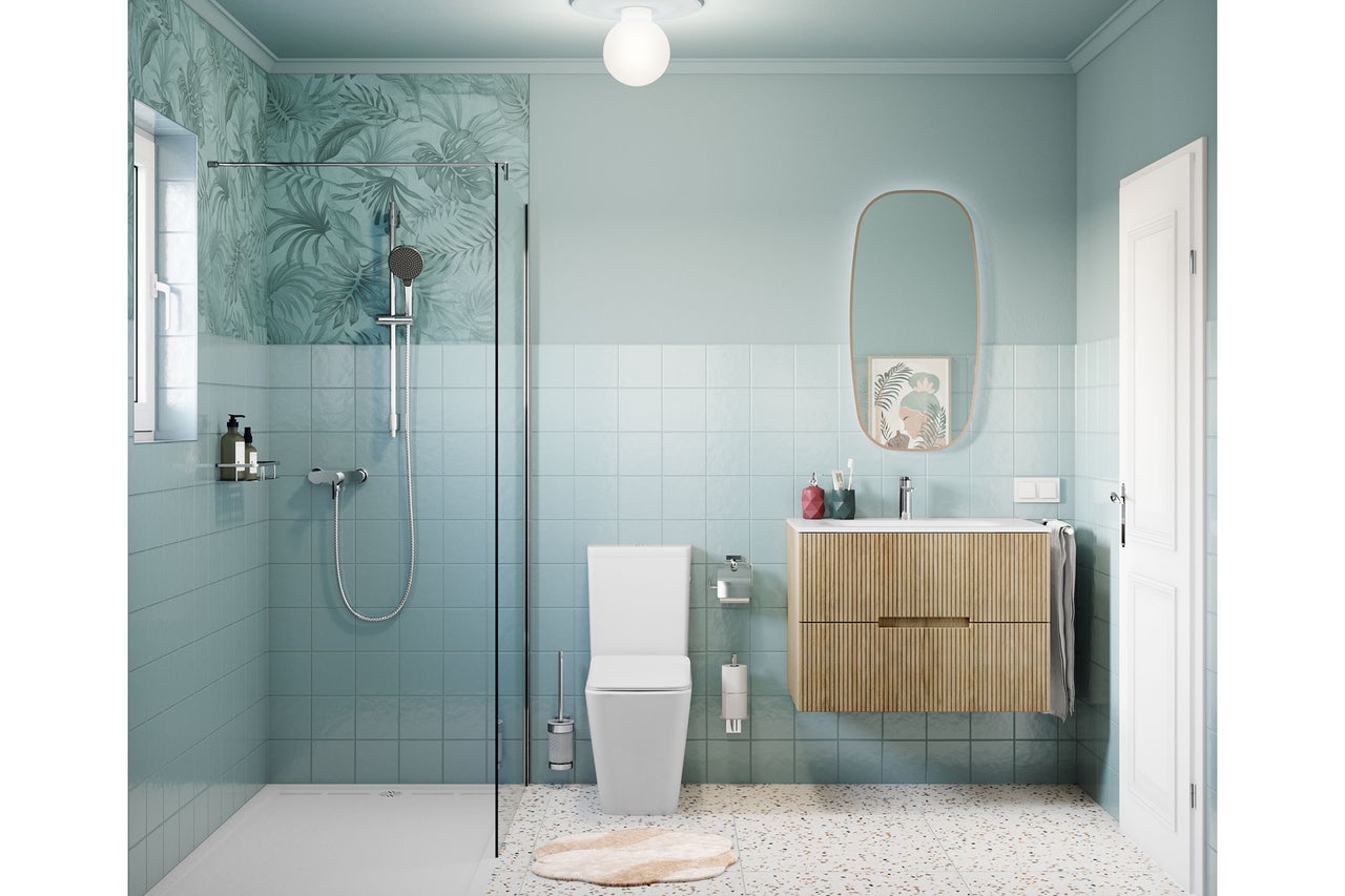 Salle de bains moderne et lumineuse avec douche à l'italienne, carrelage bleu, meuble sous-vasque en bois et WC blanc au sol en terrazzo.
