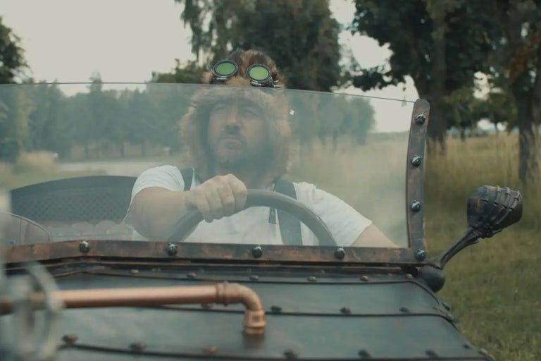Un homme portant un bonnet de fourrure et des lunettes de protection conduit un véhicule de style steampunk