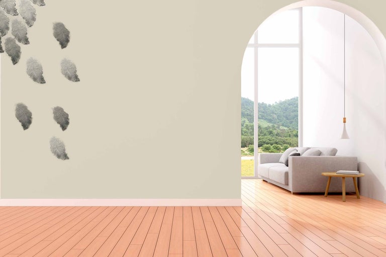 Salon avec sticker mural plume, canapé et plancher en bois