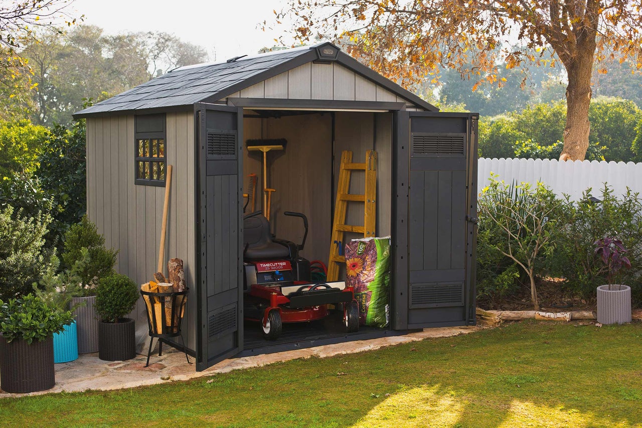 Jardin avec abri de jardin, tondeuse à gazon et outils de jardinage