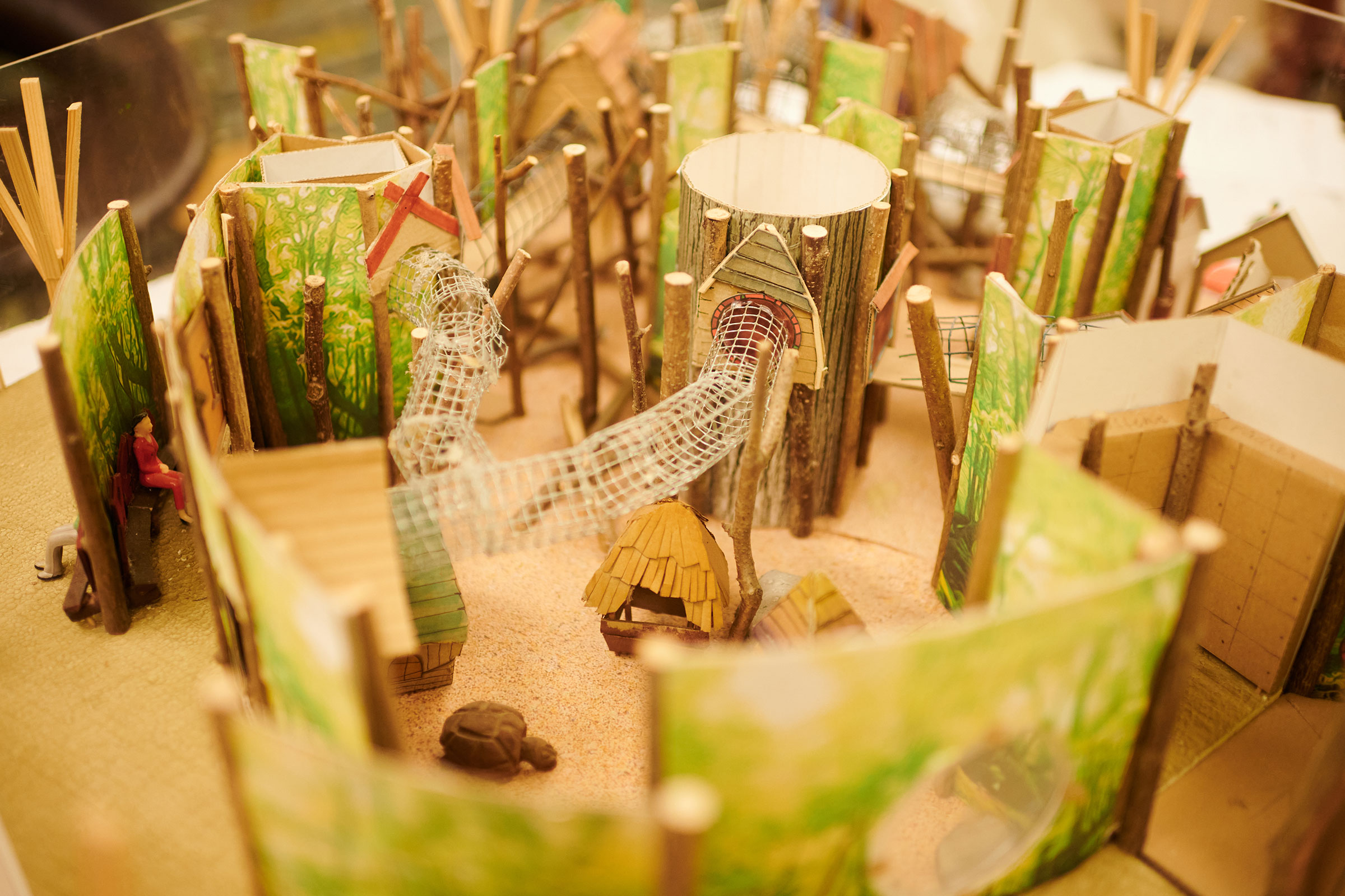 Detailansicht eines Baumhausmodells mit Holzelementen und Miniaturfiguren