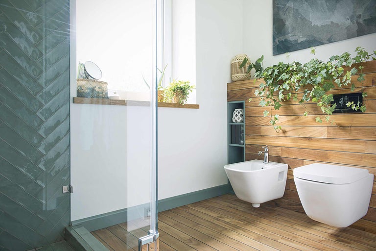 Salle de bains moderne avec douche, bidet et WC sur un mur en bois avec des plantes