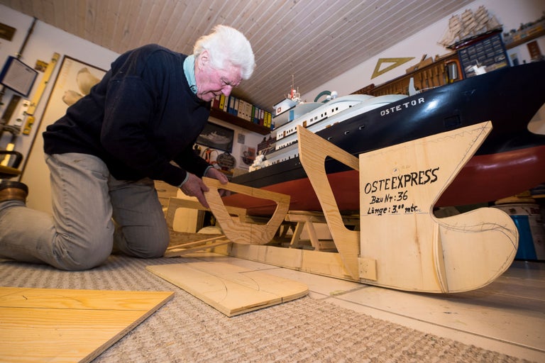 Ein Mann baut ein Holzschiffsmodell der 'Oste Express' in seinem Hobbyraum