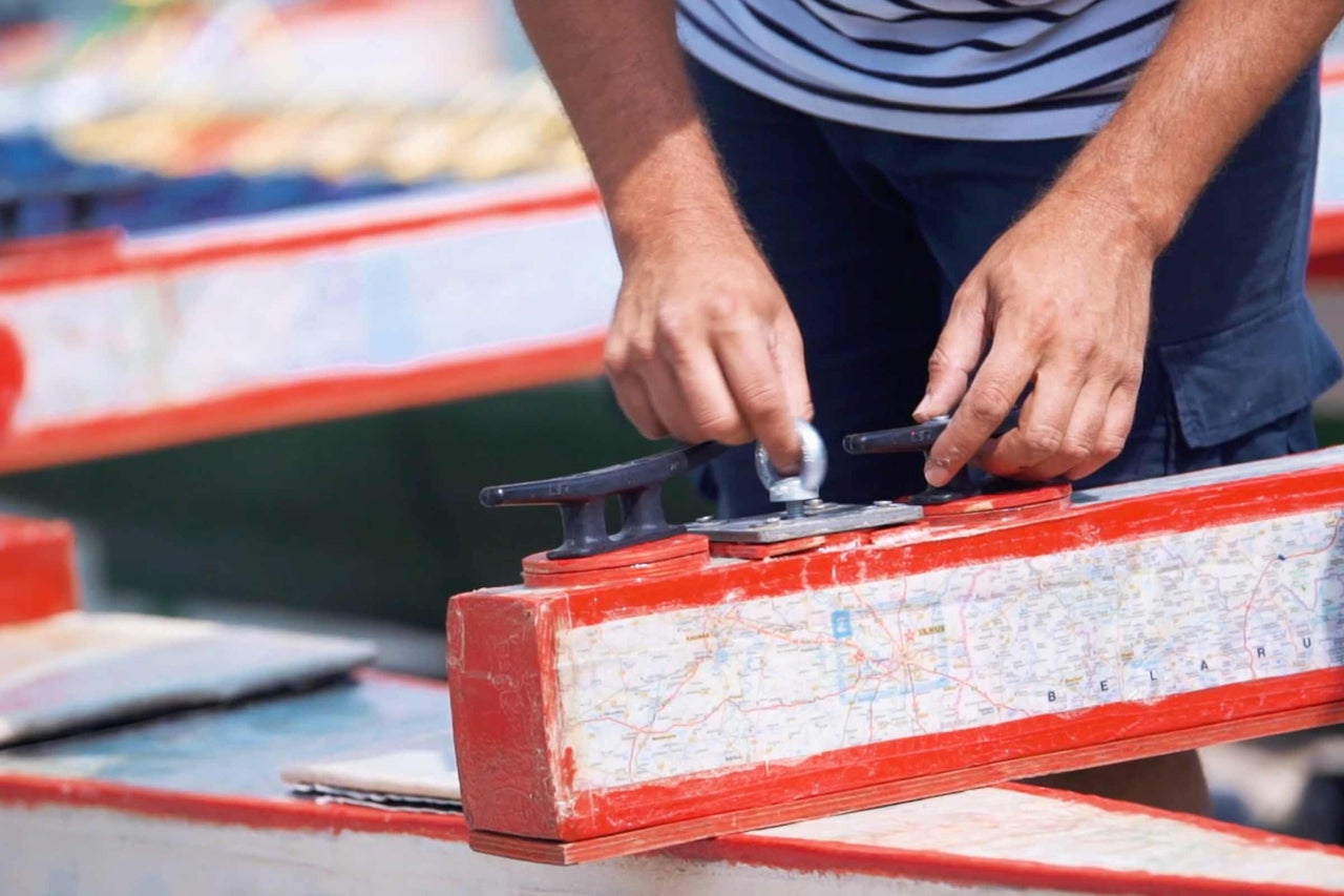Un homme fixe un taquet de bateau sur un bateau avec une carte