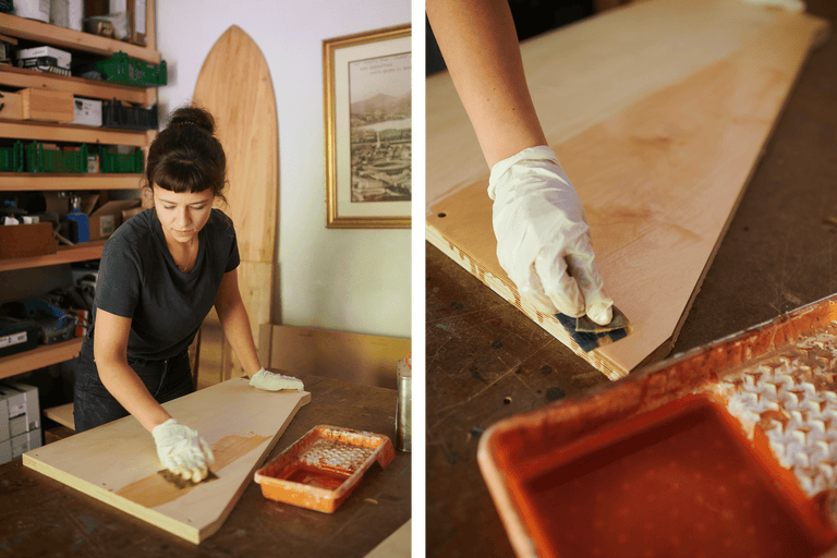 Une femme applique une couche de vernis sur une plaque de bois. Scène d'atelier.