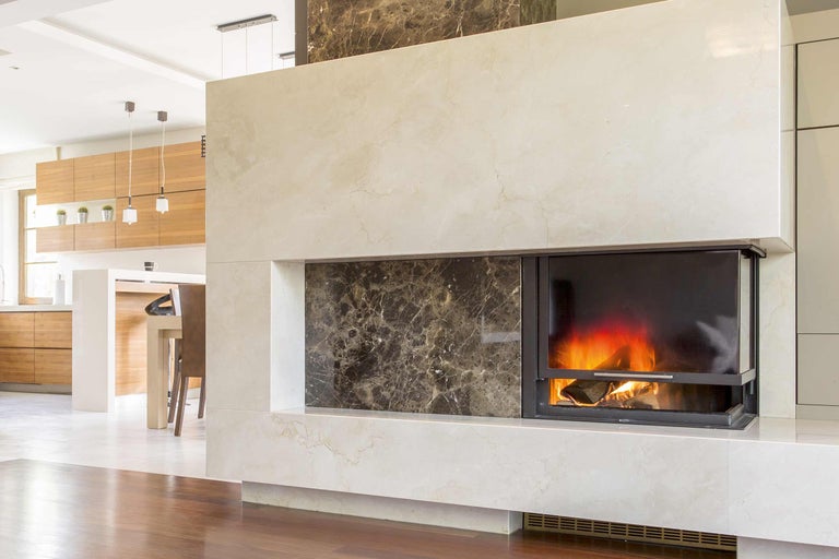 Moderner Kamin aus Marmor mit brennendem Holz
