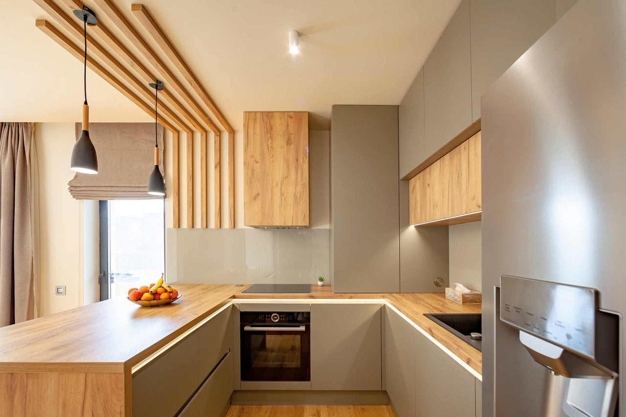 Cuisine moderne avec plan de travail en bois, armoires de cuisine et appareils électroménagers.