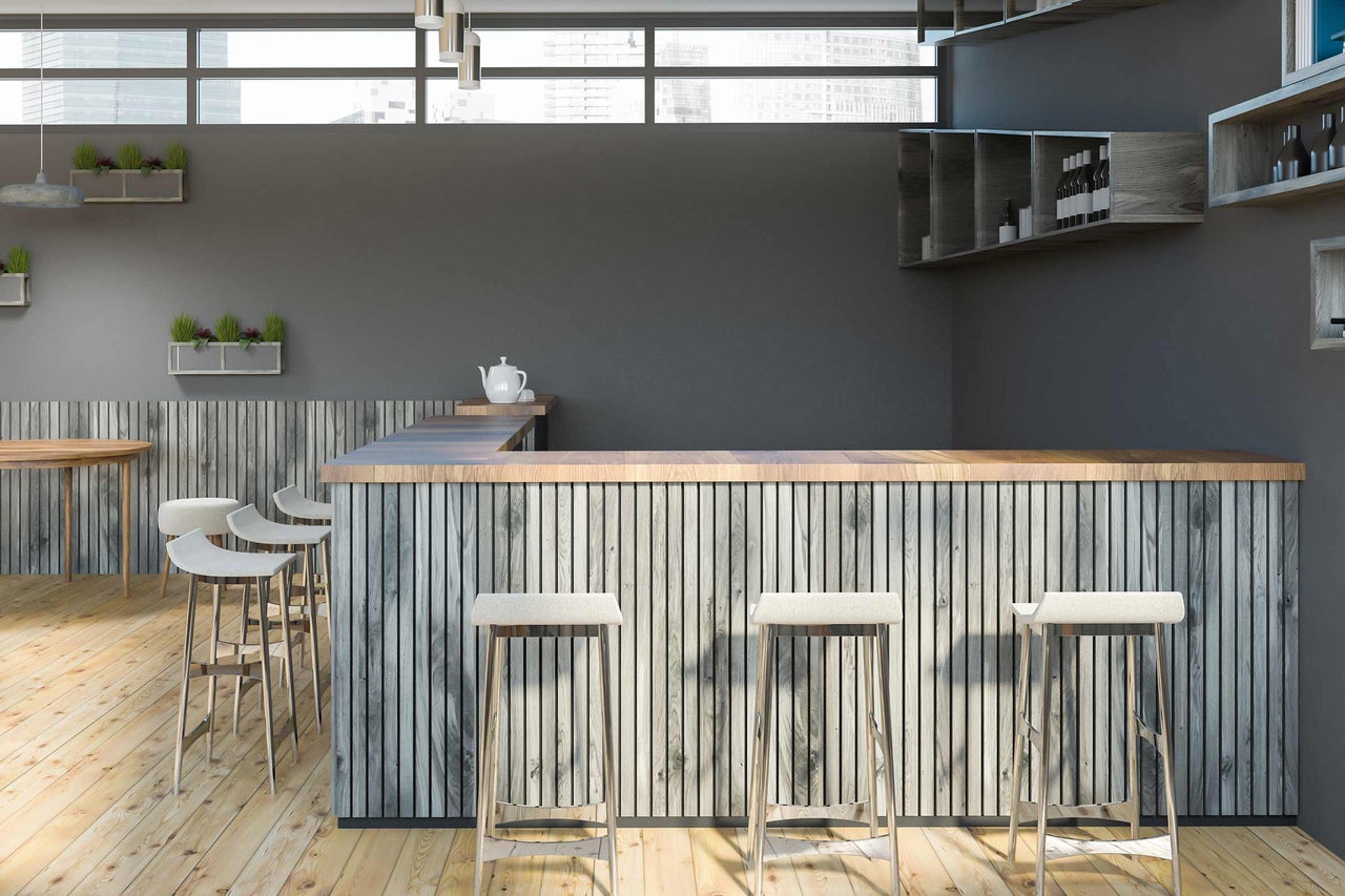 Photo d'intérieur d'un bar avec des éléments en bois et des tabourets de bar