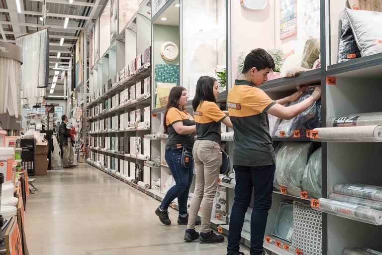 Innenansicht eines Hornbach Baumarktes mit Regalen gefüllt mit Tapeten und Kissen