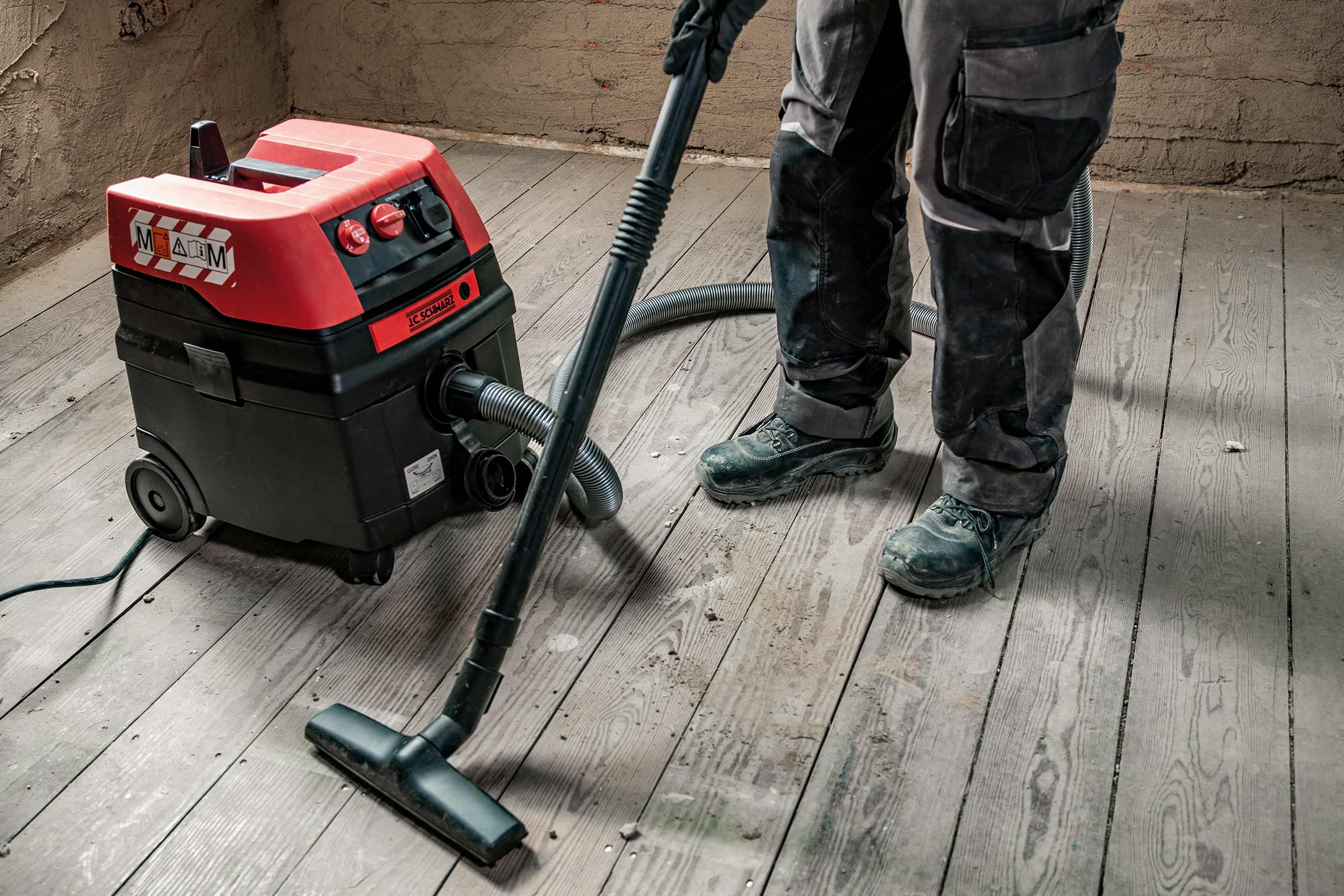 Aspirateur industriel nettoyant un plancher en bois.