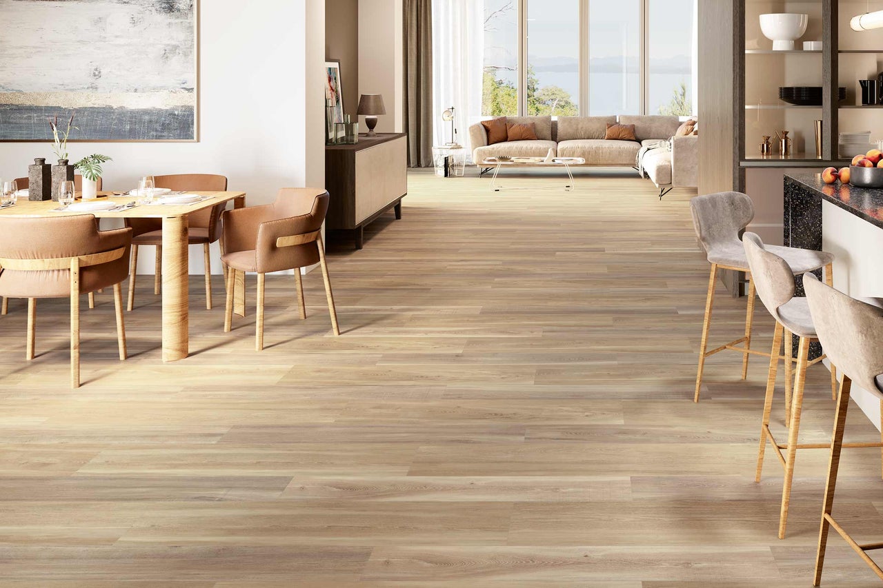 Salon lumineux avec plancher en bois, table à manger, chaises et tabourets de bar.