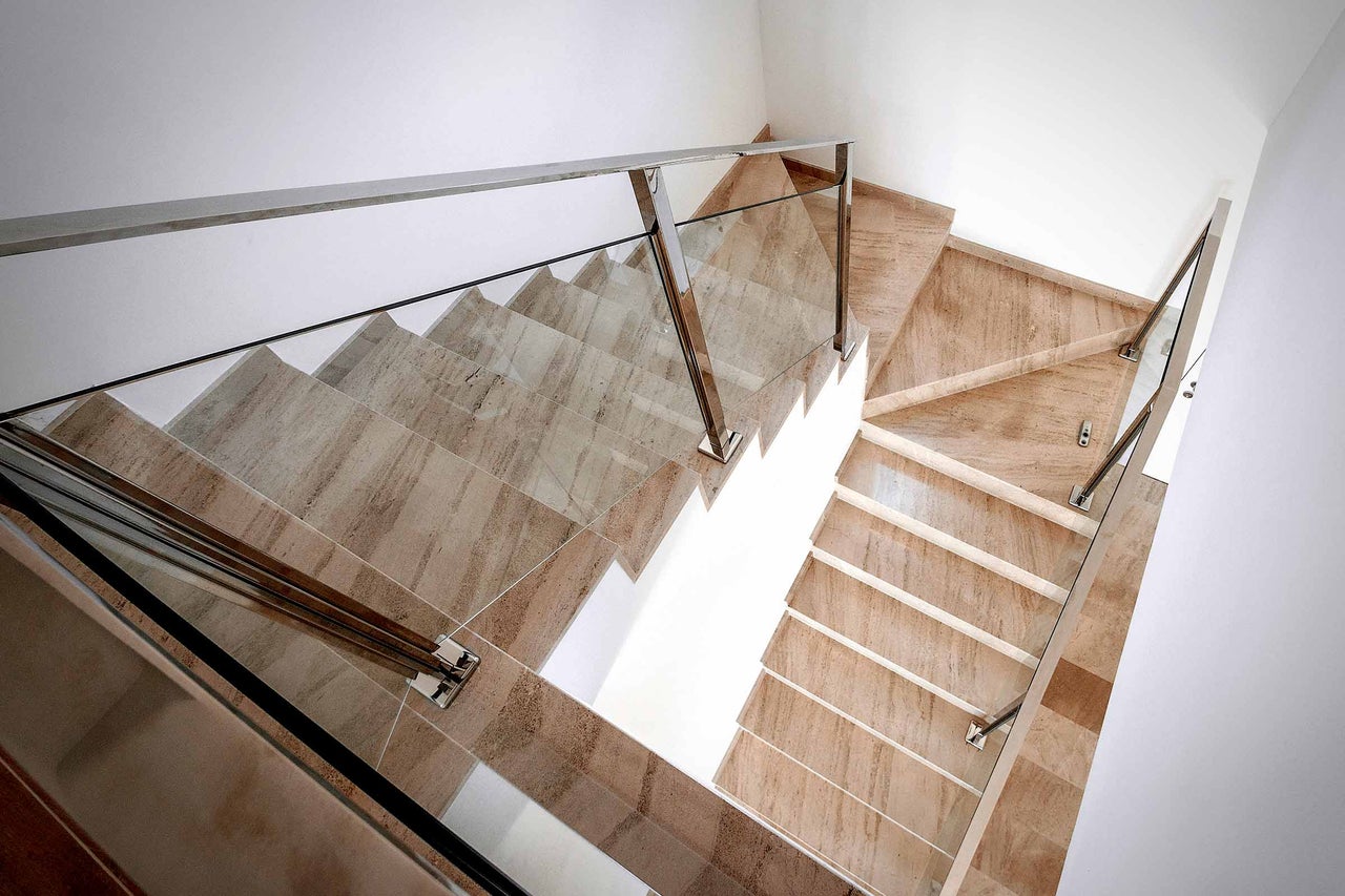 Treppe mit Marmorstufen und Glasgeländer