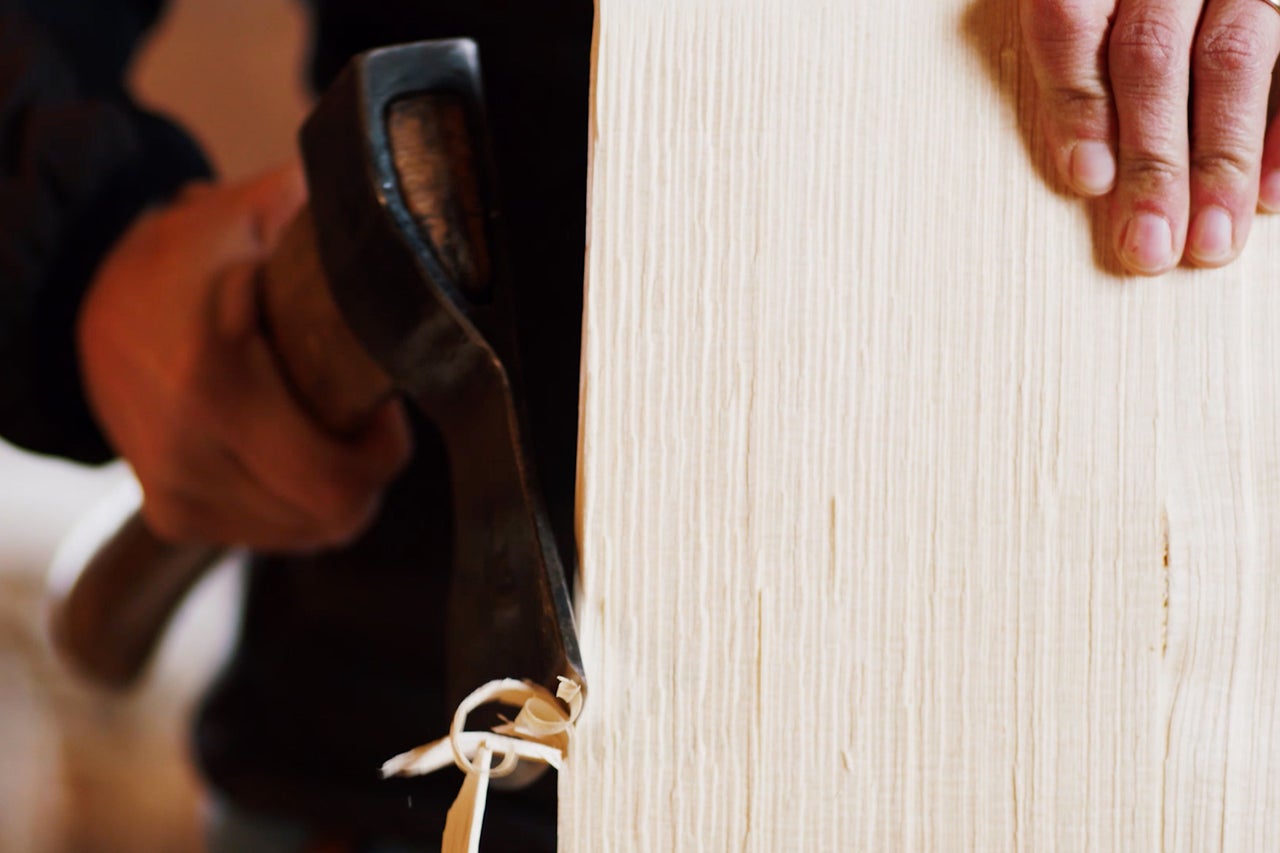 Hobel bearbeitet ein Holzbrett