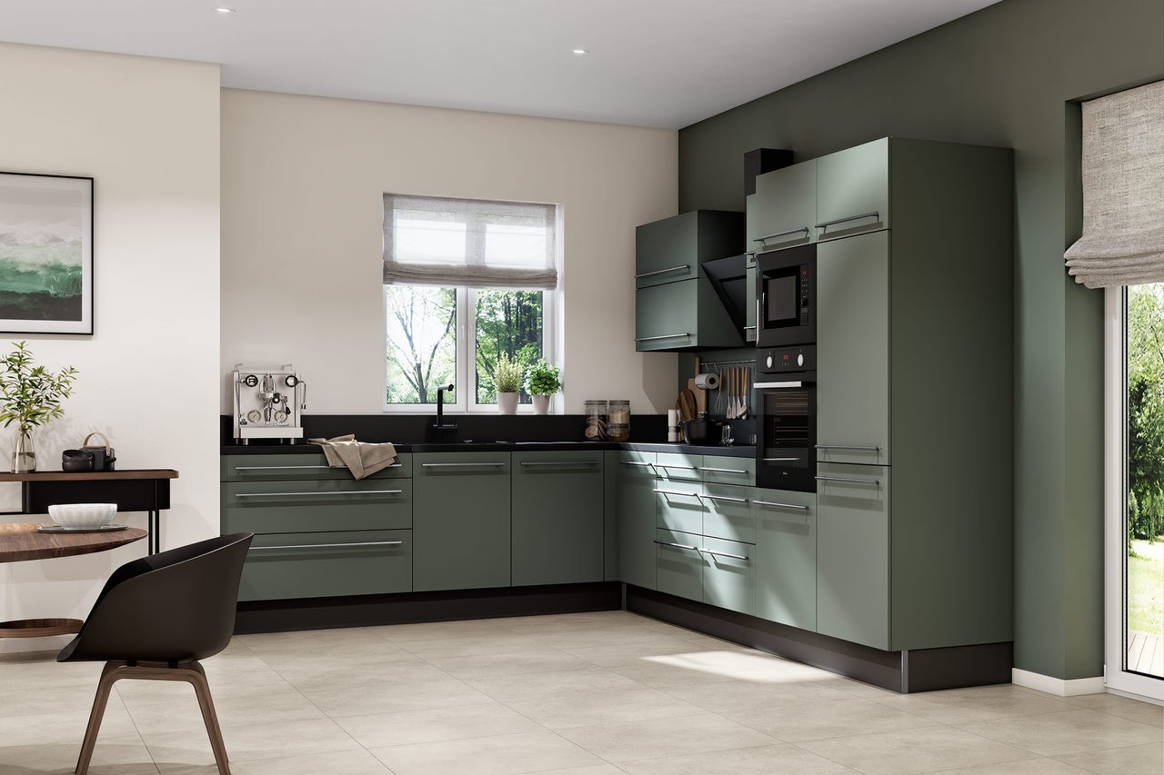 Cuisine d angle moderne avec façades vert olive, plan de travail noir, appareils encastrés et table à manger dans une pièce lumineuse.