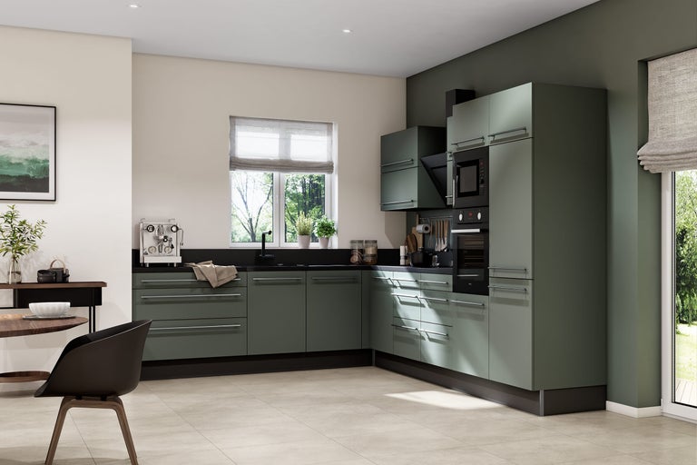 Cuisine d angle moderne avec façades vert olive, plan de travail noir, appareils encastrés et table à manger dans une pièce lumineuse.