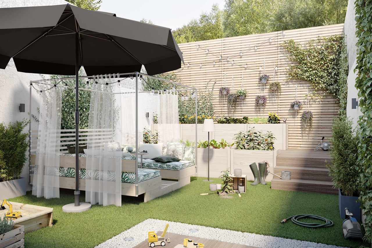 Scène de jardin lumineuse avec parasol, lit de jardin avec rideaux, plates-bandes surélevées, bac à sable et outils de jardin sur pelouse