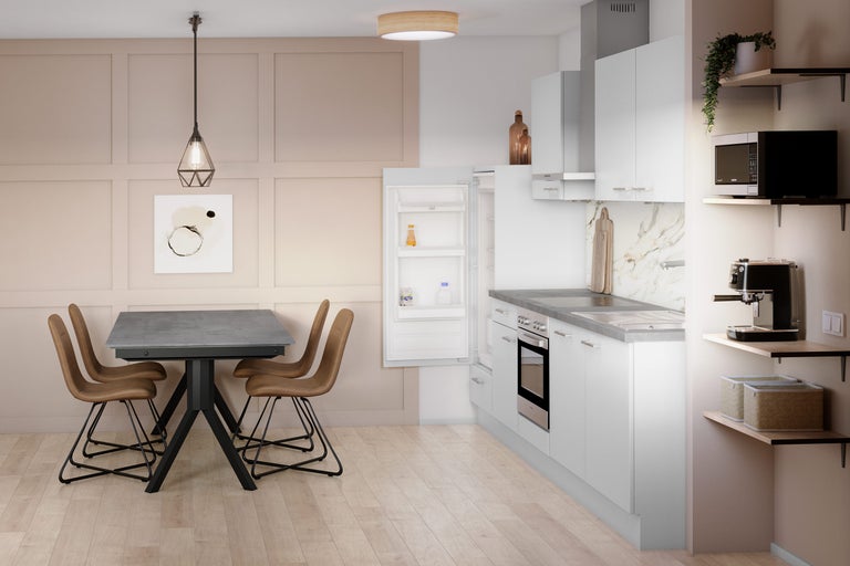 Helle Küche mit Esstisch, Stühlen, Einbaukühlschrank und Küchengeräten.