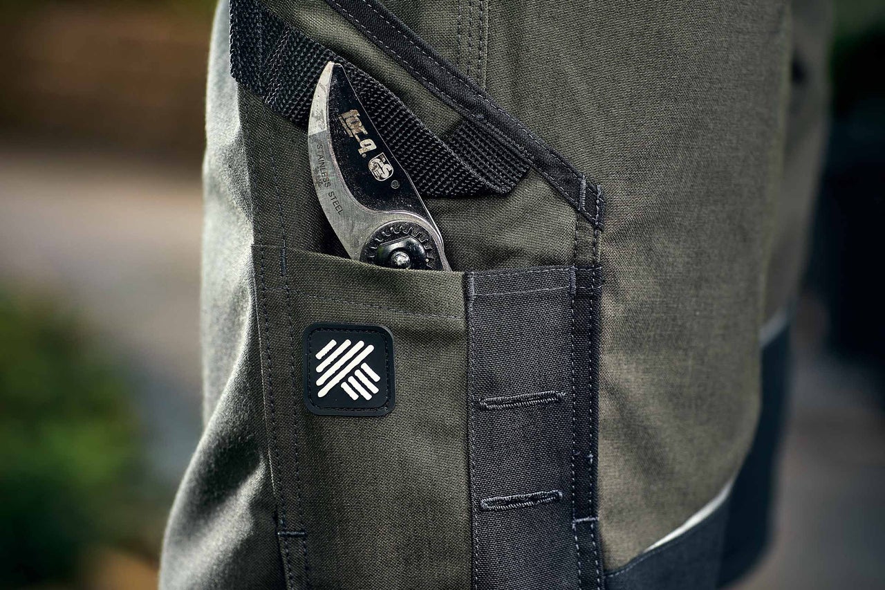 Detailaufnahme einer Arbeitshose mit einer Gartenschere in der Tasche