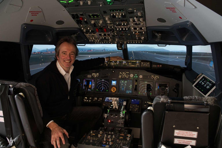 Mann sitzt im Cockpit eines Flugzeugs und blickt auf die Startbahn.