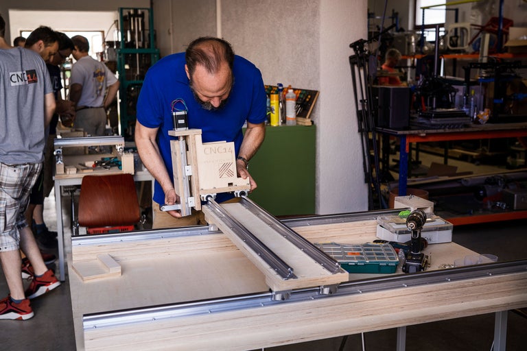 Mann arbeitet an einer Holzfräsmaschine in einer Werkstatt.