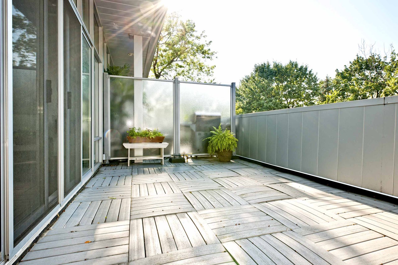 Balcon avec dalles en bois, pare-vue et jardinières