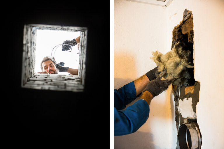Ein Mann untersucht einen Schornstein und dämmt eine Wandöffnung mit Glaswolle