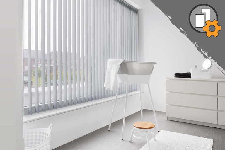 Salle de bain lumineuse avec fenêtre, équipée de stores, baignoire, tabouret et commode.