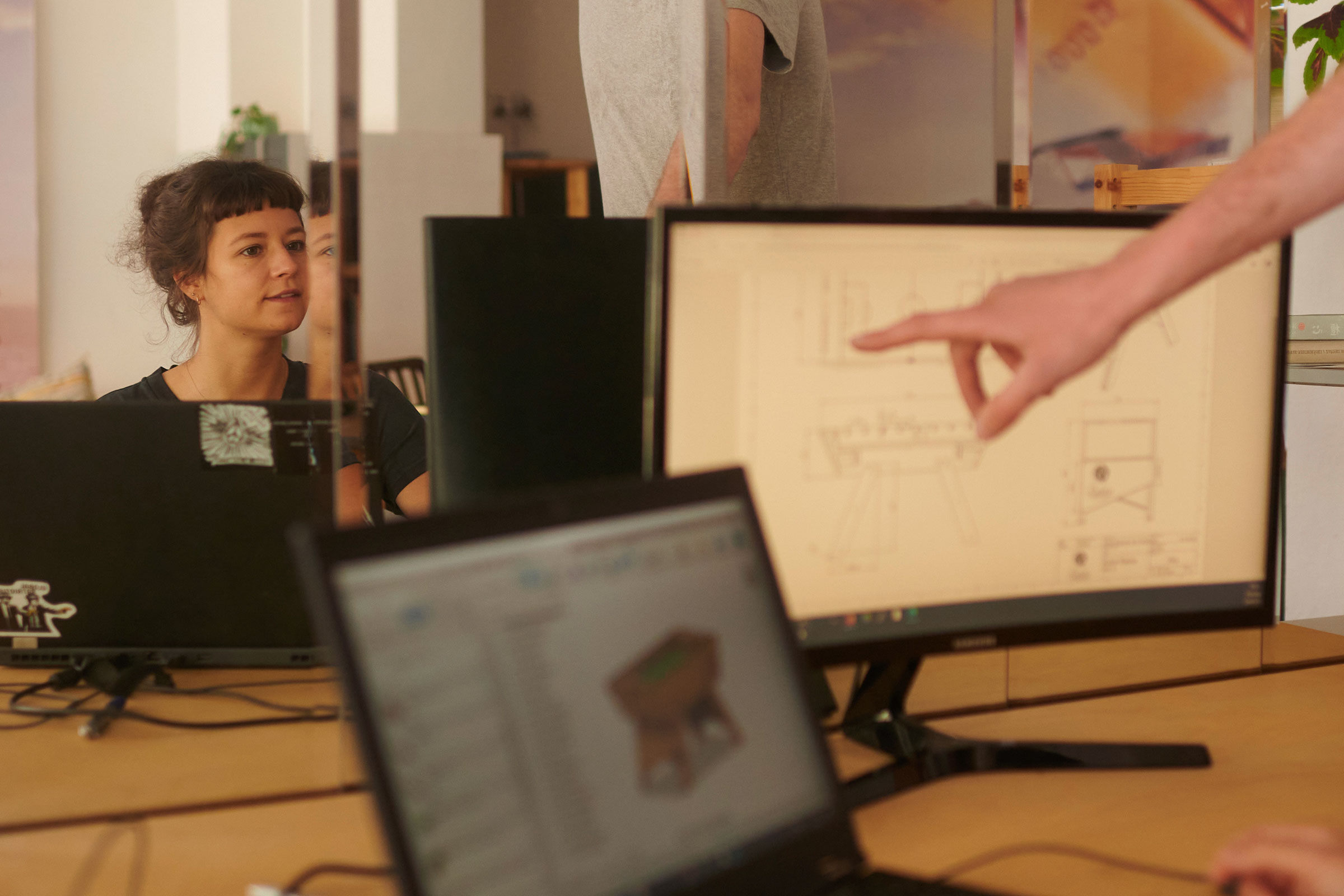 Personen arbeiten an Computern mit technischer Zeichnung am Bildschirm
