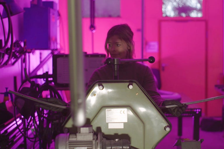 Une femme travaille avec une cintreuse Zopf dans un atelier.