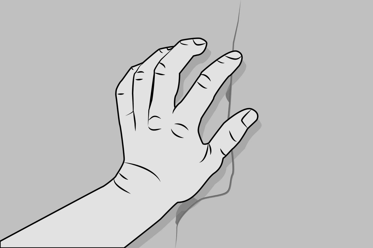 Main sur une fissure dans le mur