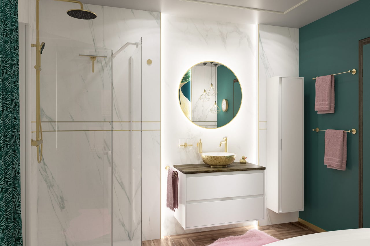 Salle de bain moderne avec mur effet marbre, douche de tête dorée, meuble sous-vasque blanc avec vasque dorée et miroir rond à LED.