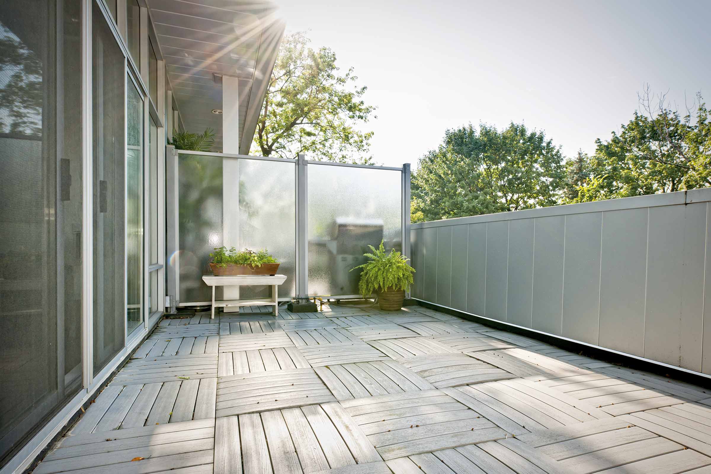 Heller Balkon mit Holzfliesen und Sichtschutz
