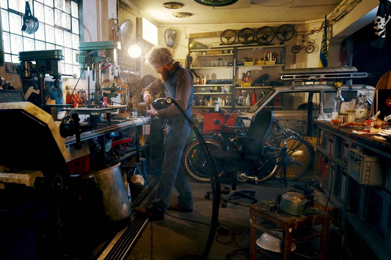 Atelier avec établi, outils et une personne au travail