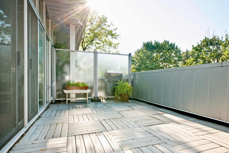 Balcon avec dalles en bois, écran de confidentialité et plantes