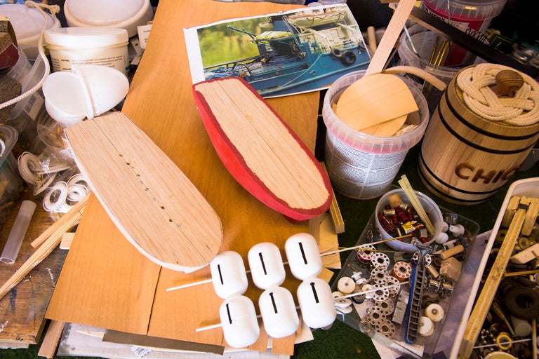 Werkstattszenen mit Werkzeugen, Holzteilen und einem Bild eines Schiffes